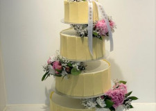 Bryllupskage 4-etager med hvid chokoladekant og friske blomster 
